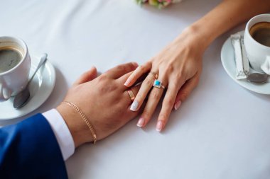 top view hands of newlyweds on table in cafe. newlyweds with wed
