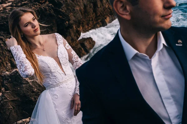 The groom in a jacket and shirt in the foreground. bride in a be — Stockfoto