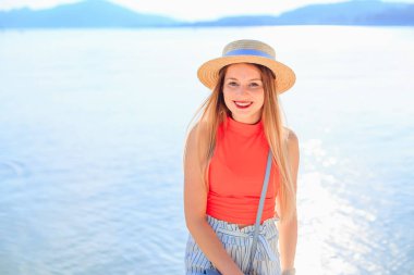 şık giysi ve hasır Çilli kız gülümsüyor ve bakmak