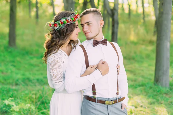 Girl in a dress and a wreath embraces the guy from the back side — 图库照片