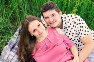 Bekleyen anne babalar kameraya bakar ve çimlere uzanır.. 