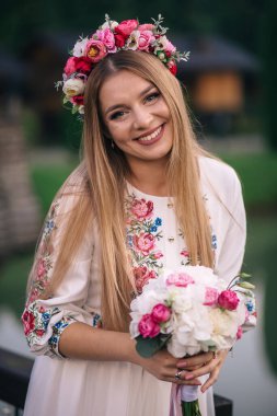 Güzel makyajlı gelin. Gülümseyen ve elinde bir düğün çantası tutan sevimli bir gelin.