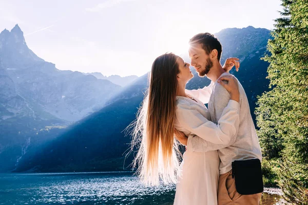 Man Omhelst Het Meisje Een Witte Jurk Voor Haar Middel — Stockfoto