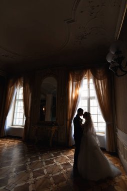 Damat gelini büyük pencereli ve aynalı lüks bir odada tutuyor. profil.