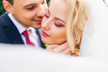 Güzel makyajlı gelin gözlerini kapadı ve damat onu öpmek istiyor. Kapat..