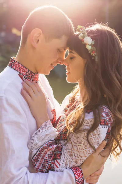 互いの腕の中で目を閉じた男と女のプロフィール 湖の刺繍入りの服を着たカップルが — ストック写真