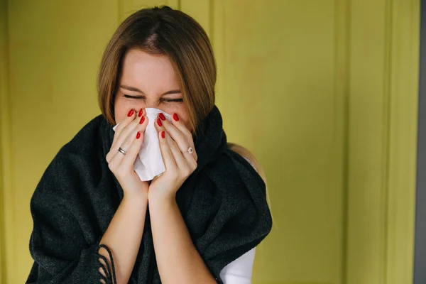 Sick woman wearing scarf, blowing nose and sneeze into tissue. female have flu, virus or allergy respiratory. Healthy, medicine and people concept. Headache and fever remedies.