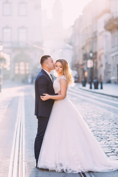 Ženich Objímá Líbá Krásnou Nevěstu Bílých Šatech Novomanželé Náměstí — Stock fotografie