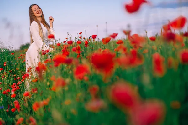 美丽的红罂粟生长在长满青草的田野里 穿着白色衣服的女孩 — 图库照片