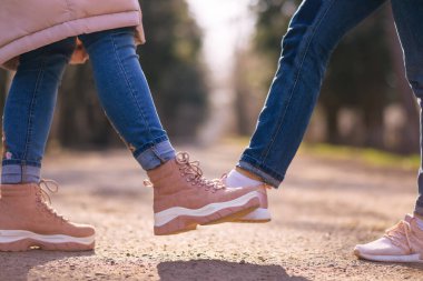 İnsanlar ayaklarıyla selam veriyor. Coronavirüs salgını sırasında alternatif tokalaşma. Covid 19. Coronavirus önleme. Temas olmayan selamlama. Selamlaşmanın ayak sallama şekli. Coronavirüs salgını.