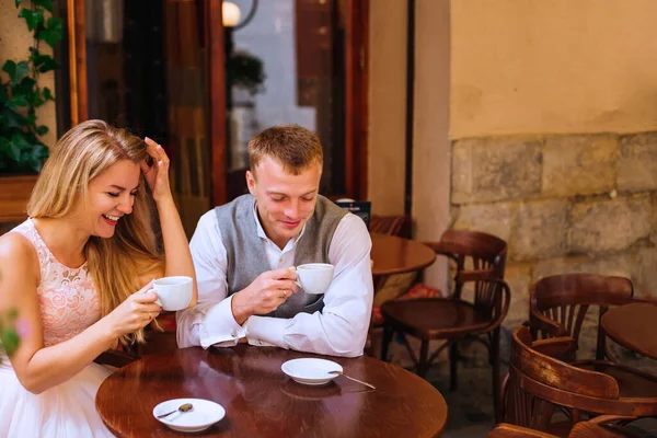 那男的和女的坐在咖啡店里 他们把头靠在地上笑着 热咖啡 — 图库照片