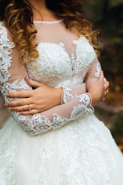 自分を抱きしめる花嫁のウェディングドレスのクローズアップ — ストック写真