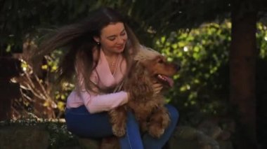 Mutlu kadın cocker spaniel dişi köpekle eğleniyor. Oynuyor ve okşuyor..