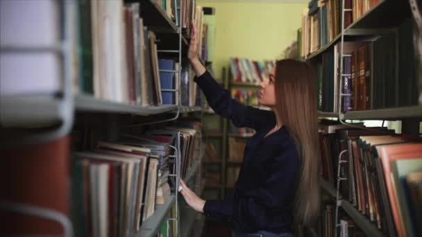 Student Bibliotheek Doet Een Onderzoek Zoek Naar Een Boek Tussen — Stockvideo