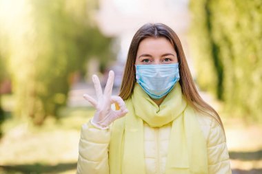 Koruyucu Maske Giyen ve Tamam işareti gösteren Kadın