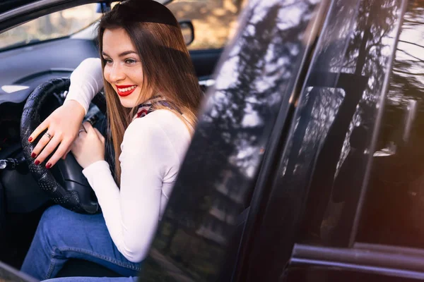Kırmızı Dudaklı Gülümseyen Genç Bir Kadın Yeni Araba Kullanıyor — Stok fotoğraf