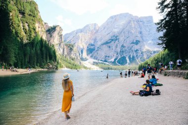Lago di Braies, İtalya - 16 Ağustos 2019 - Dağlardaki turkuaz gölün arka planında kayıkçı kız. Dolomitler Alpler, lago di Braies, İtalya.