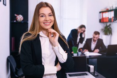 happy team leader, mentor smiling in office. smile at camera with coworkers on background clipart