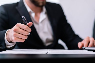 Resmi olarak genç işadamı elinde kalem, kırpılmış mermi taşıyor.