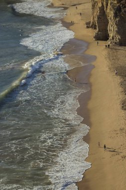 Okyanus dalgaları ve kum uçurumlar yanındaki