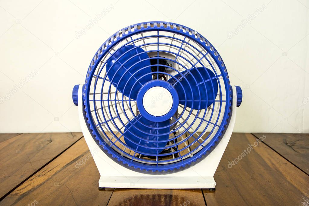 Blue mini fan on wooden floor