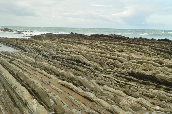 Geological Formations On The Beach With Finish On The Sea Of The Flysch Type Geopark Basque Route UNESCO. Filmed Game Of Thrones. Itzurun Beach. Geology Landscapes Travel. Zumaia Guipouzcoa Basque Country Spain.