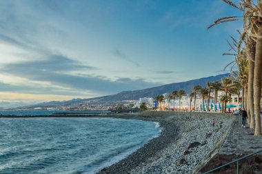 Las Americas Sahili 'nde gün batımında güzel bir turuncu gökyüzüyle gezinti. 11 Nisan 2019. Santa Cruz de Tenerife İspanya Afrika. Seyahat Turizmi Sokak Fotoğrafçılığı.