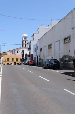 Santa Ana Kilisesi 'nin çan kulesi Garachico' nun yakınlarındaki sokakların küçük binaları arasında görüldü. 14 Nisan 2019. Garachico, Santa Cruz De Tenerife İspanya Afrika. Seyahat Turizmi Sokak Fotoğrafçılığı.