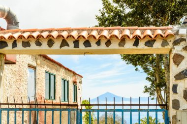La Gomera Adası 'ndaki klasik mavi bir kapının arkasındaki El Teide Volkanı. 15 Nisan 2019. La Gomera, Santa Cruz de Tenerife İspanya Afrika. Seyahat Turizmi Fotoğraf Doğası.