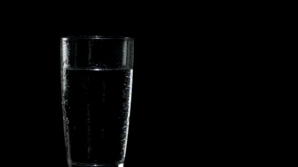 Un verre d'eau humide est situé sur le côté gauche de l'écran 