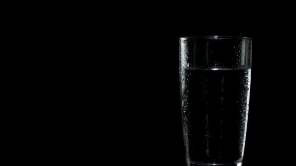 Um copo de água sai do lado direito da tela e pára à esquerda — Vídeo de Stock