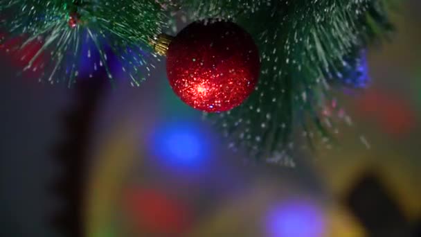 Bola roja de Navidad colgando en el árbol, la cámara gira en un círculo — Vídeo de stock