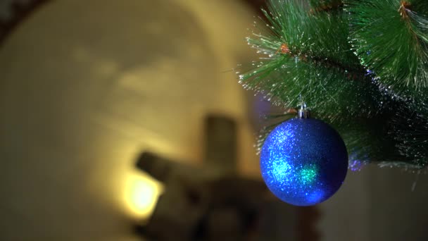 Blauwe Kerstbal in de flikkering van gekleurde lichten. — Stockvideo