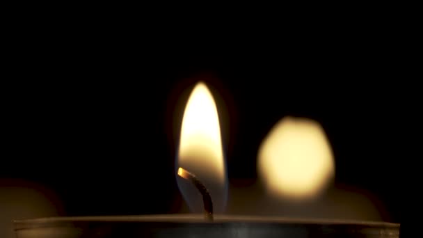 Спокойное пламя горящей свечи в темноте — стоковое видео