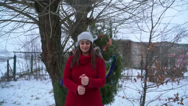 Ein Mädchen auf der Straße im Dorf sprengt einen Christbaumknacker — Stockvideo