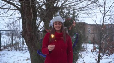 A girl lights a Sparkler in winter, the countryside in slow motion