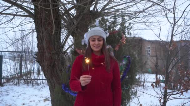 Ein Mädchen zündet im Winter eine Wunderkerze an, die Landschaft in Zeitlupe — Stockvideo