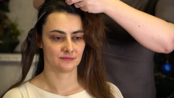 De stylist doet de meisjes haar met behulp van haarklemmen — Stockvideo