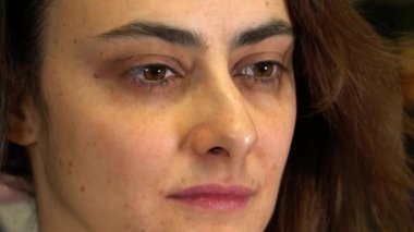 Kız stilistte oturuyor ve düşünceli görünüyor.