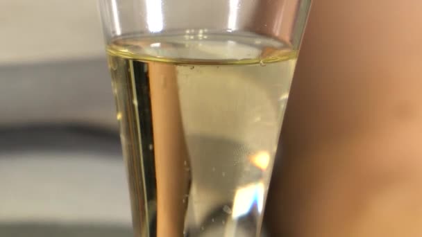 Bubliny šampaňského stoupají na povrch skla — Stock video