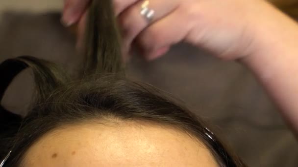 El estilista prepara el pelo de las niñas y lo riza con una plancha de rizar — Vídeos de Stock