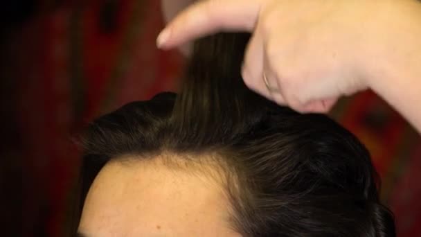 Stylista prostuje kosmyki włosów grzebieniem — Wideo stockowe