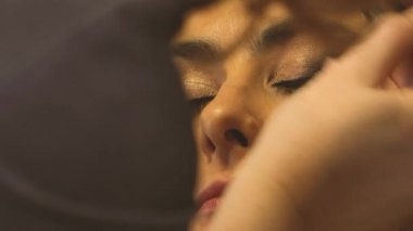 Makyöz kız yüzüne makyaj yapar.