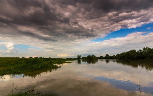 Ominous stormy sky in spring, over wild river