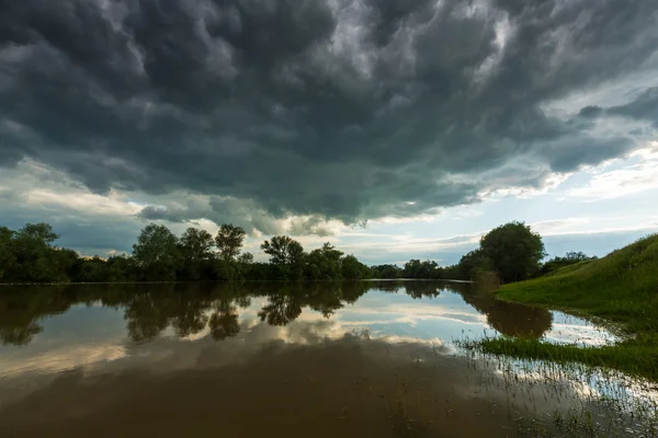 Ominous stormy sky in spring, over wild river