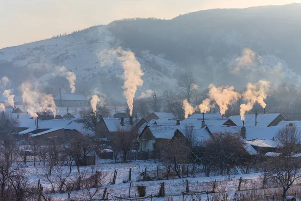 Güzel kış manzarası ile Avrupa'nın uzak kırsal kesimde bir parlak, soğuk, sabahı ev bacalar gelen duman