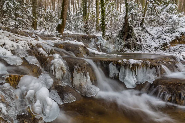 Wilder Fluss, wunderschöne gefrorene Wasserfälle und frischer Schnee in einem Bergwald, an einem kalten Wintertag — Stockfoto