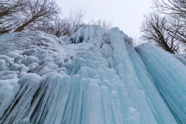 Wilder Fluss, wunderschöne gefrorene Wasserfälle und frischer Schnee in einem Bergwald, an einem kalten Wintertag — Stockfoto