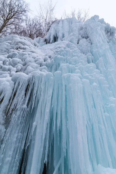 Wilder Fluss, wunderschöne gefrorene Wasserfälle und frischer Schnee in einem Bergwald, an einem kalten Wintertag — Stockfoto