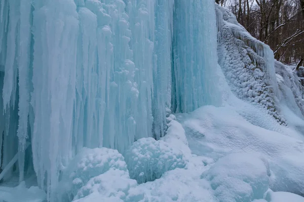 Wilder Fluss, wunderschöne gefrorene Wasserfälle und frischer Schnee in einem Bergwald, an einem kalten Wintertag — Stockfoto